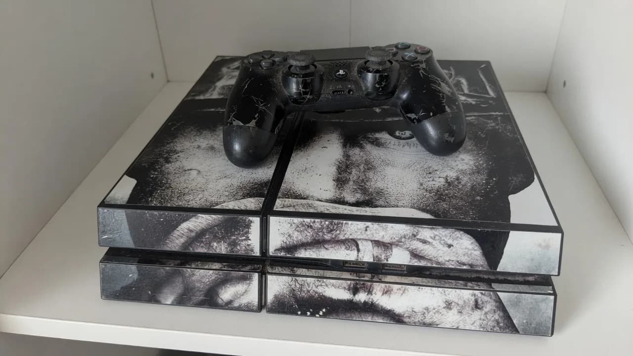 Used PlayStation 4 with a worn portrait skin and a worn controller