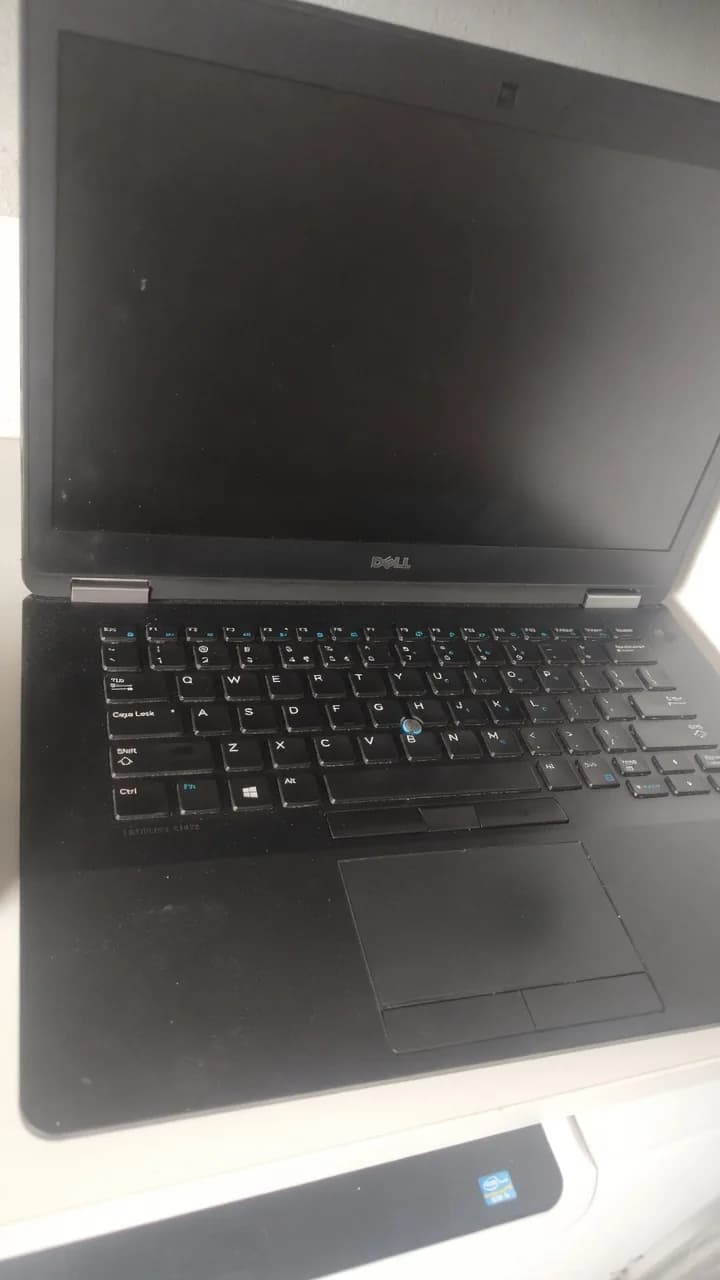 Open used black Dell Latitude laptop with a dusty keyboard