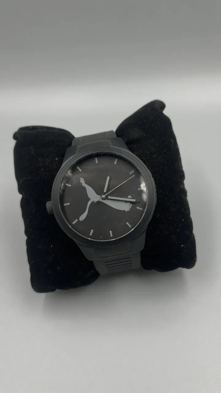 Used black Puma wristwatch with marks on the glass