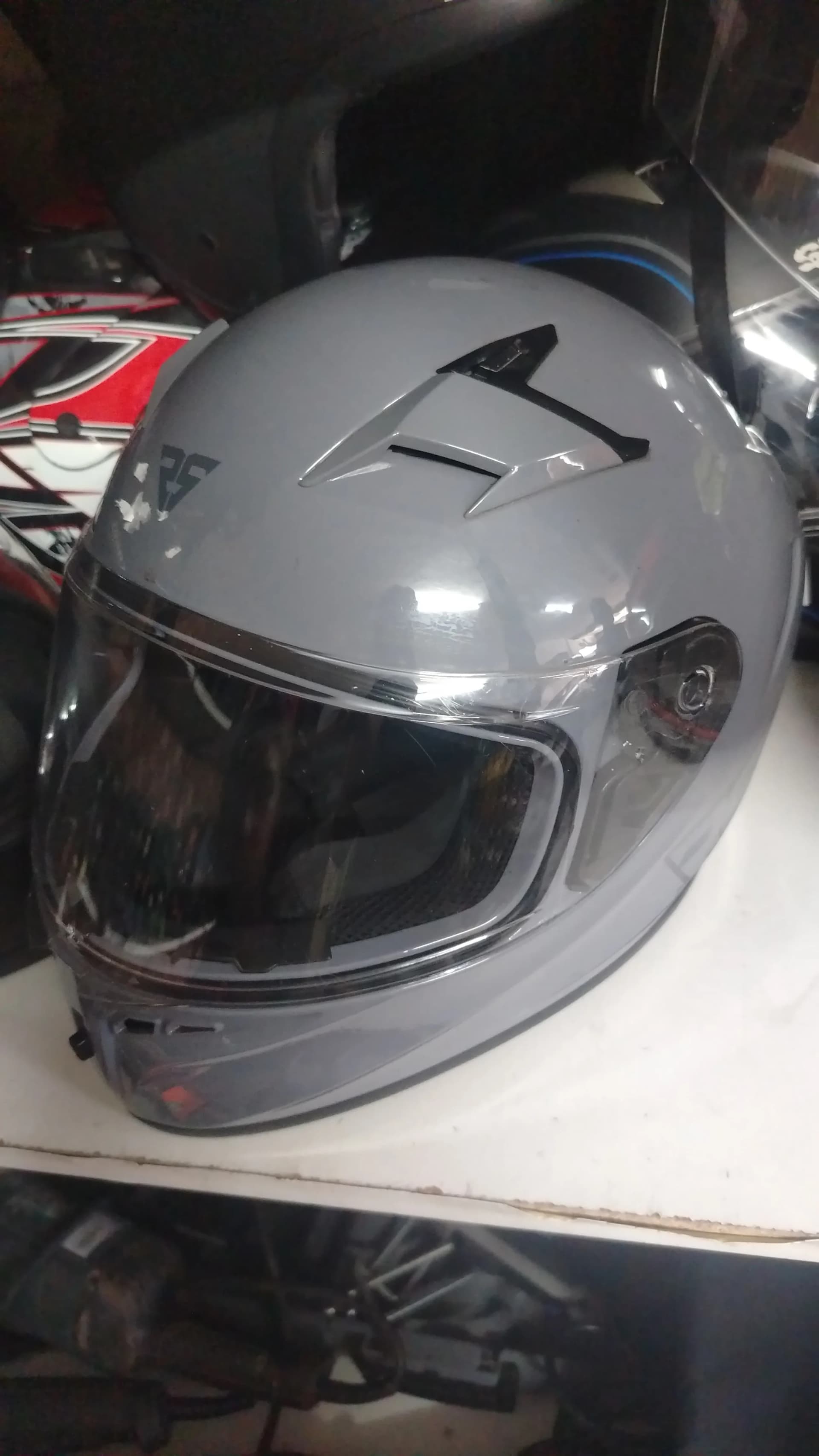Front of a used grey motorcycle helmet