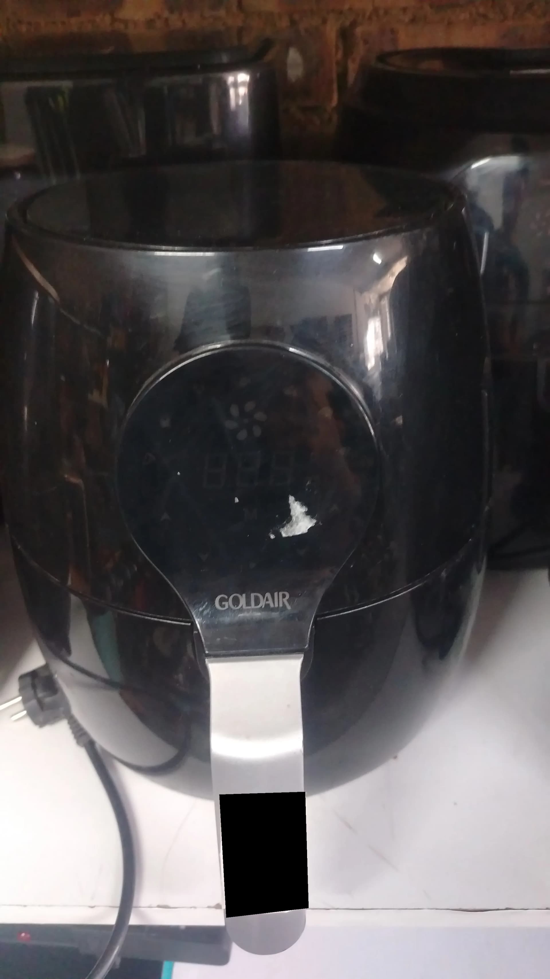 Used black Goldair air fryer with a white chip on the front